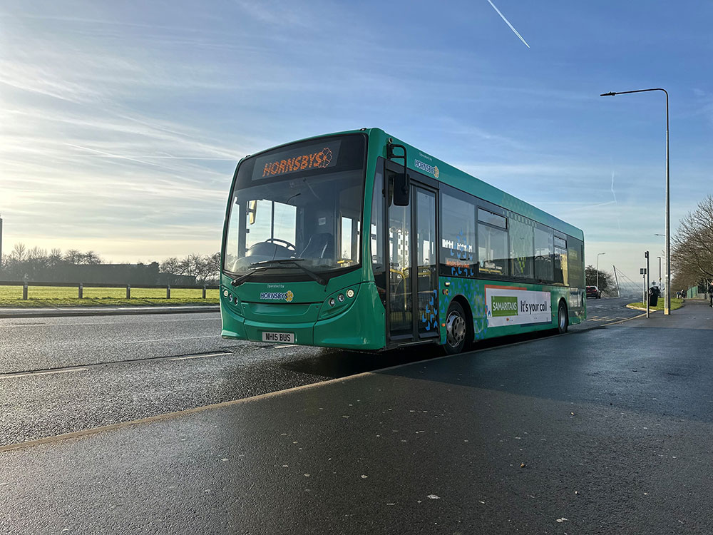 Hornsby Travel Bus parked on a road, with a wrap advertising the Samaritans charity.