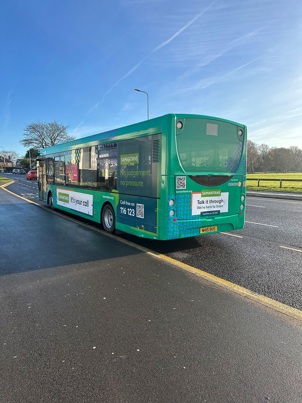 Hornsby Travel Bus parked on a road, with a wrap advertising the Samaritans charity.
